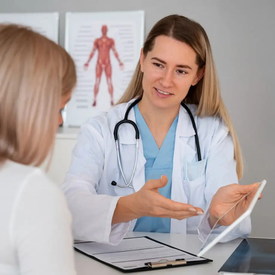 Doctor in a white coat and stethoscope discussing medical information with a patient