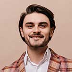 Smiling man wearing a plaid jacket.