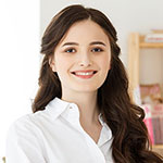 Smiling woman with long hair wearing white shirt.