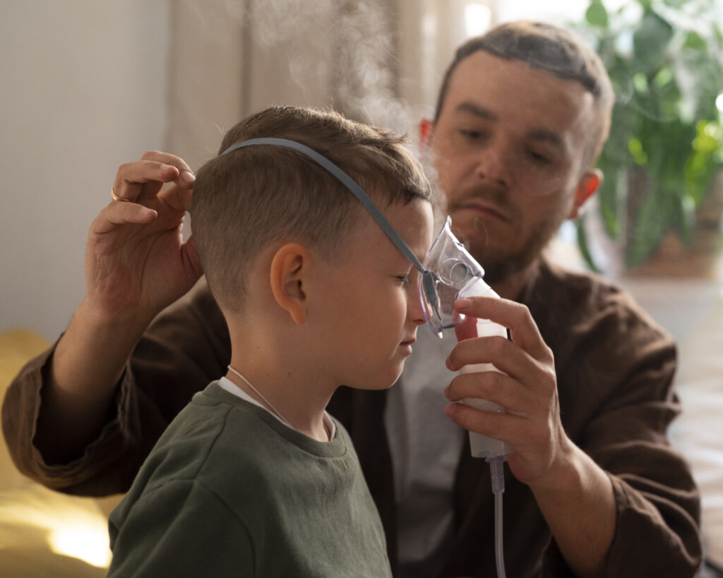 Father helping child with nebulizer treatment at home.