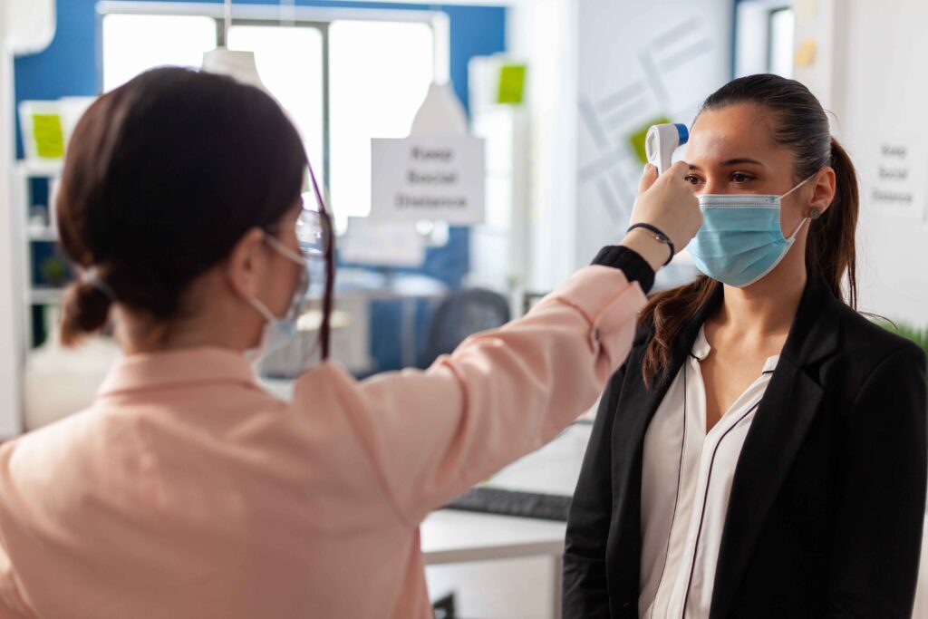 Measuring temperature with infrared thermometer during checkup.